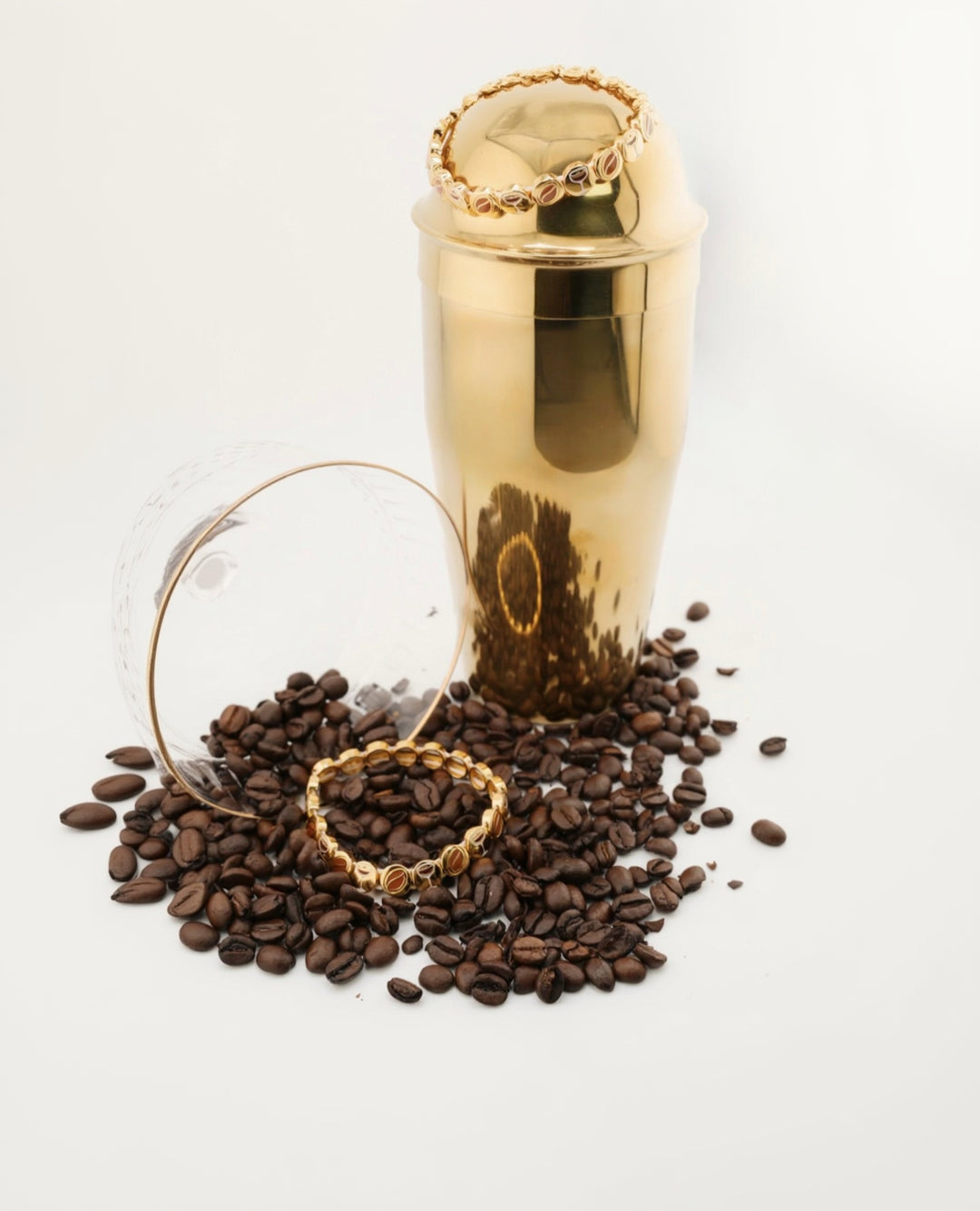 Gold cocktail shaker with coffee beans on a white background ft. espresso martini bracelet