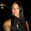 Woman with tattoos and a cross necklace at night