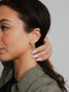Close-up of a woman wearing earrings with a neutral background