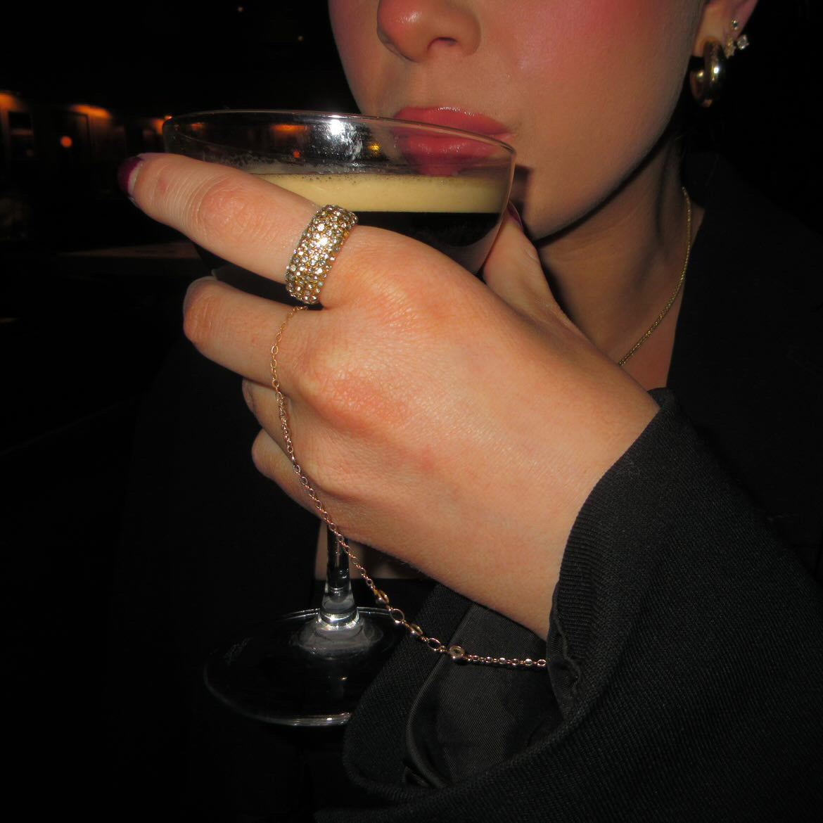 Person holding a cocktail glass with a dark background paired with the Iced Ave Ring from AV Jewels Jewelry