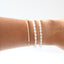 Pearl bracelets on a person's wrist against a white background