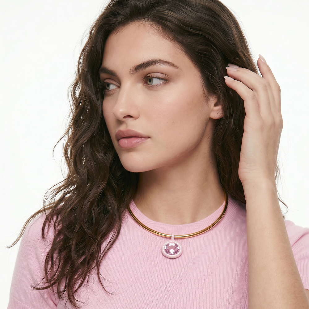 Woman wearing a pink shirt and gold necklace with a pink pendant on a white background for AV Jewels jewelry wear your moment - birth stone necklace